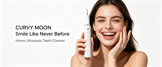Smiling woman holding a white handheld oral-care device beside her face