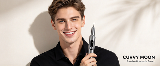 Smiling man holding a gray Curvy Moon handheld tooth cleaner beside portable ultrasonic scaler branding.